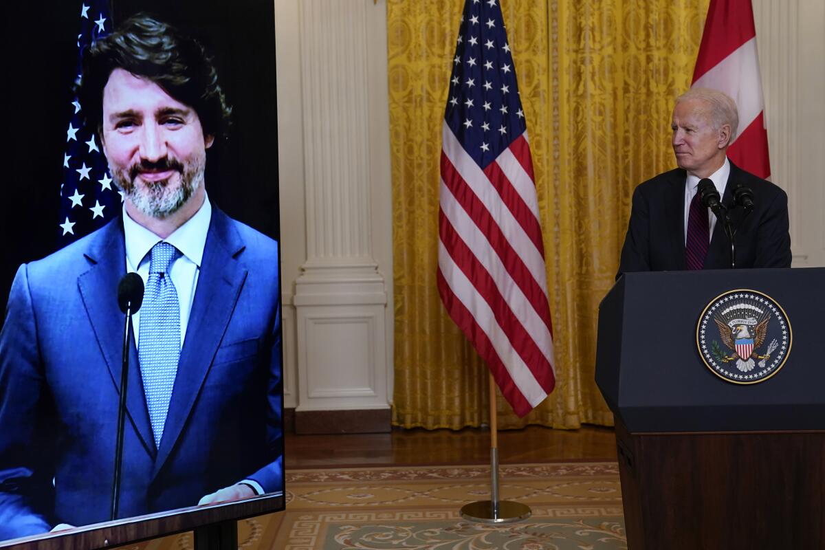 President Biden watches Canadian Prime Minister Justin Trudeau on a screen.