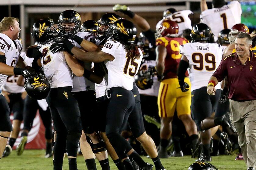 Sun Devils quarterback Mike Bercovici is swarmed by teammates after completing a 46-yard touchdown pass to wide receiver Jaelen Strong on the game's final play to defeat USC on Saturday night at the Coliseum.
