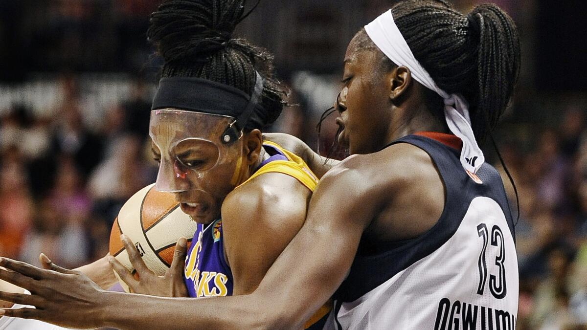 Sparks forward Nneka Ogwumike, left, drives to the basket while being guarded by her sister Chiney Ogwumike of the Connecticut Sun during the Sparks' 90-64 win Sunday.