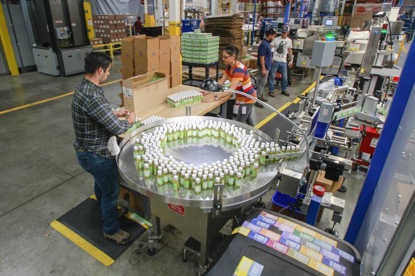 Employees work in the packaging area at the factory for the Dr. Bronner's company on October 24, 2019 in Vista, California.