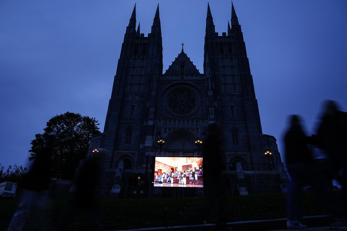 A video screen is set up at a church, seen in silhouette 