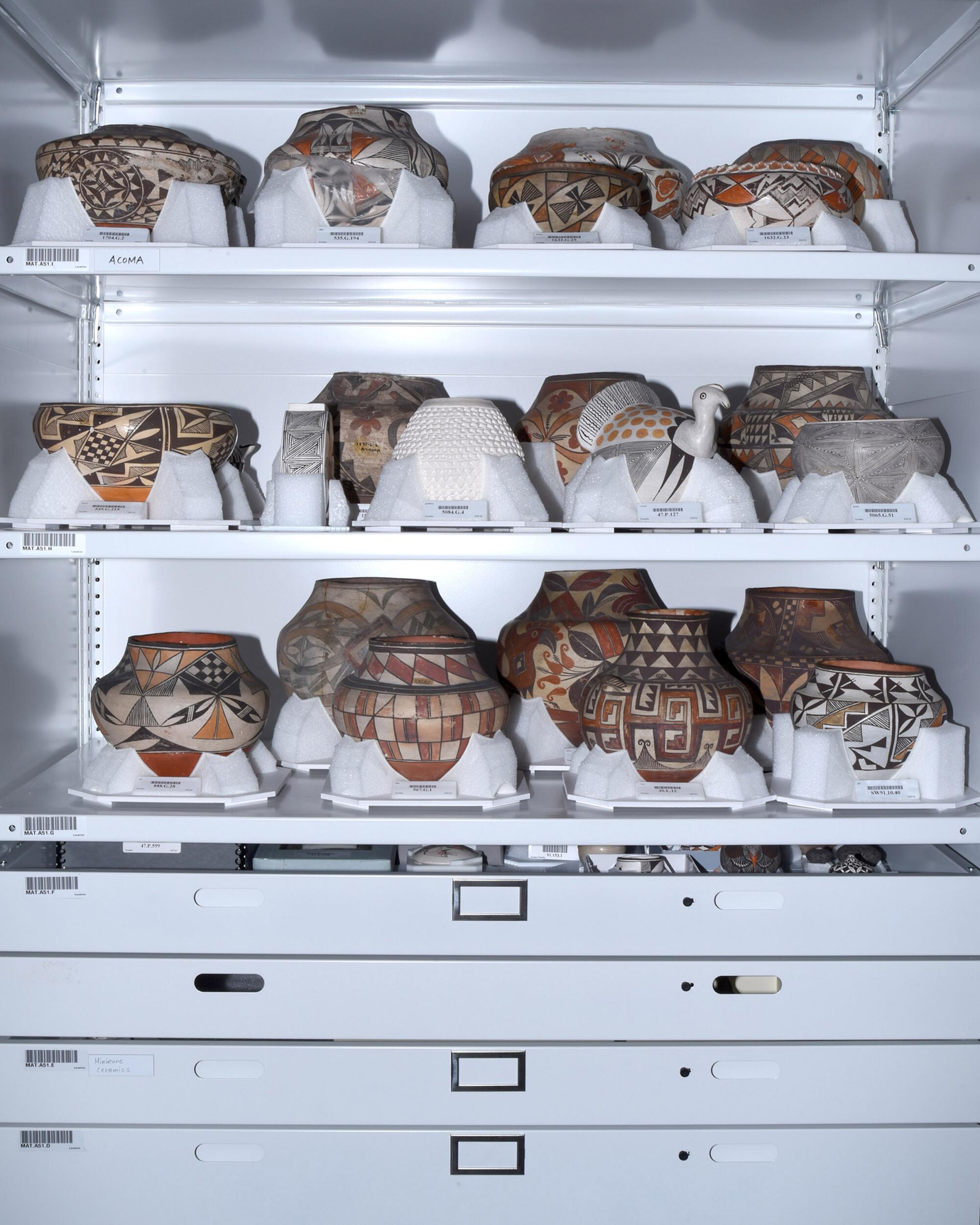 Acoma ceramics in rows on storage shelves