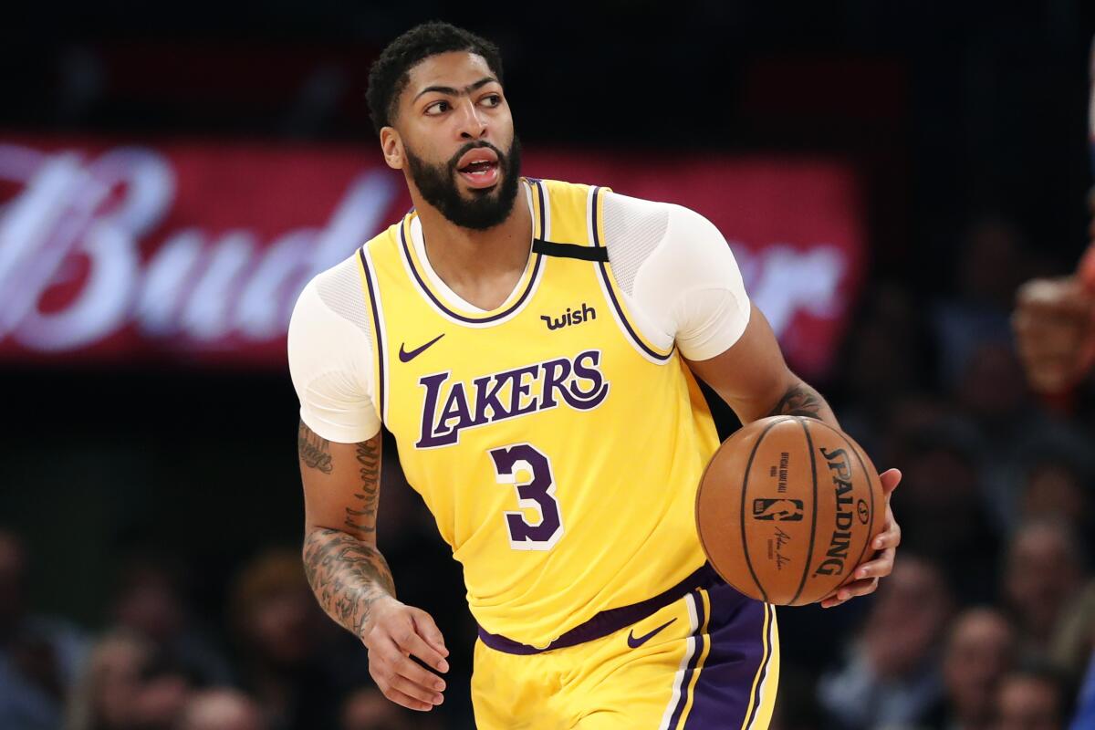 Lakers forward Anthony Davis brings the ball up court during a game.
