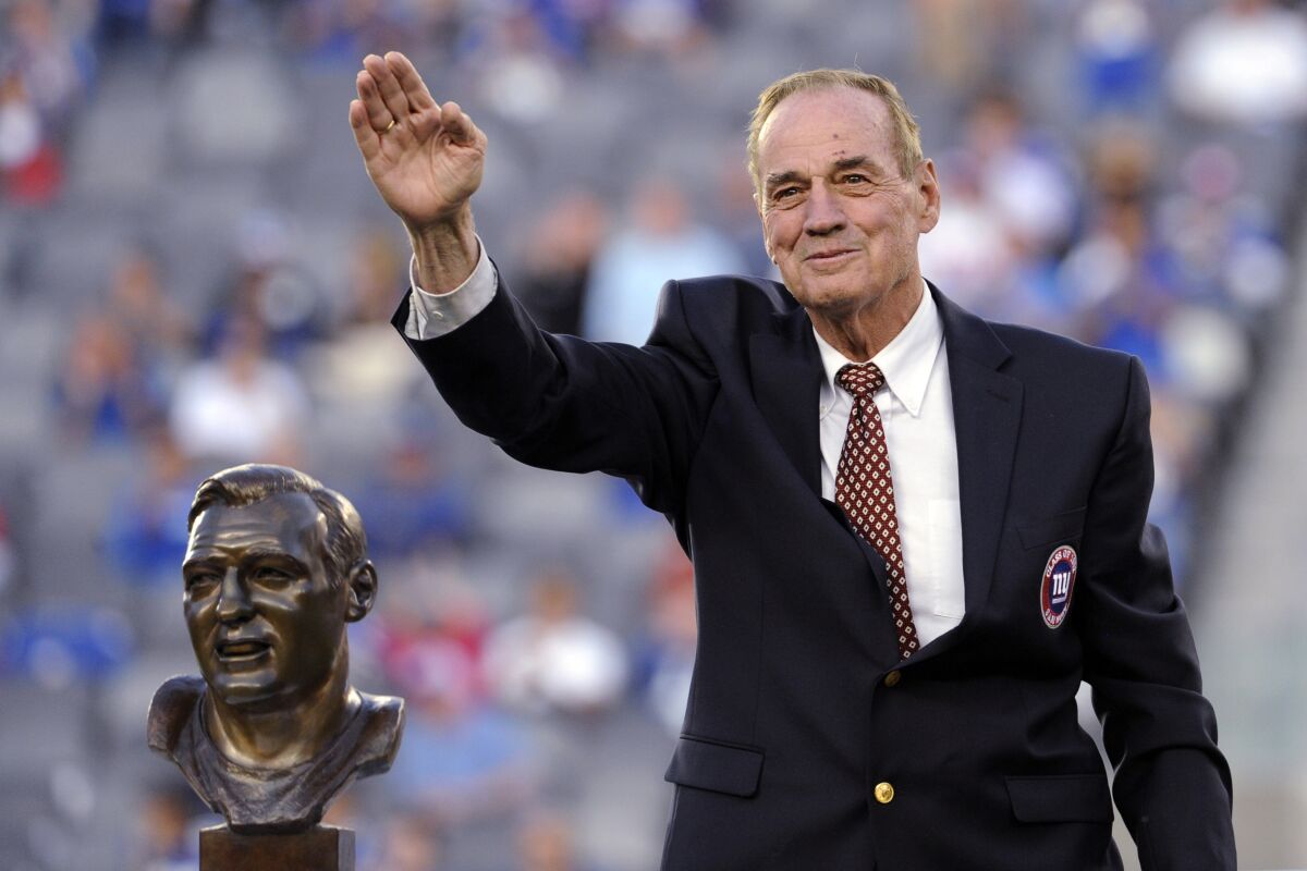 FILE - Former New York Giants linebacker Sam Huff waves to the fans as he stands behind his Hall of Fame bust during the halftime show of an NFL football game between the Giants and the Denver Broncos on Sept. 15, 2013, in East Rutherford, N.J. Huff, the hard-hitting Hall of Fame linebacker who helped the Giants reach six NFL title games from the mid-1950s to the early 1960s and later became a popular player and announcer in Washington, died Saturday, Nov. 13, 2021. He was 87. (AP Photo/Bill Kostroun File)