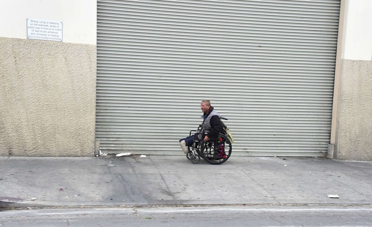 A handicapped man transports himself on a wheelchair near skid row on May 12. A report released by the Los Angeles Homeless Authority on May 11 showed a 12% increase in the homeless population in both Los Angeles city and county.