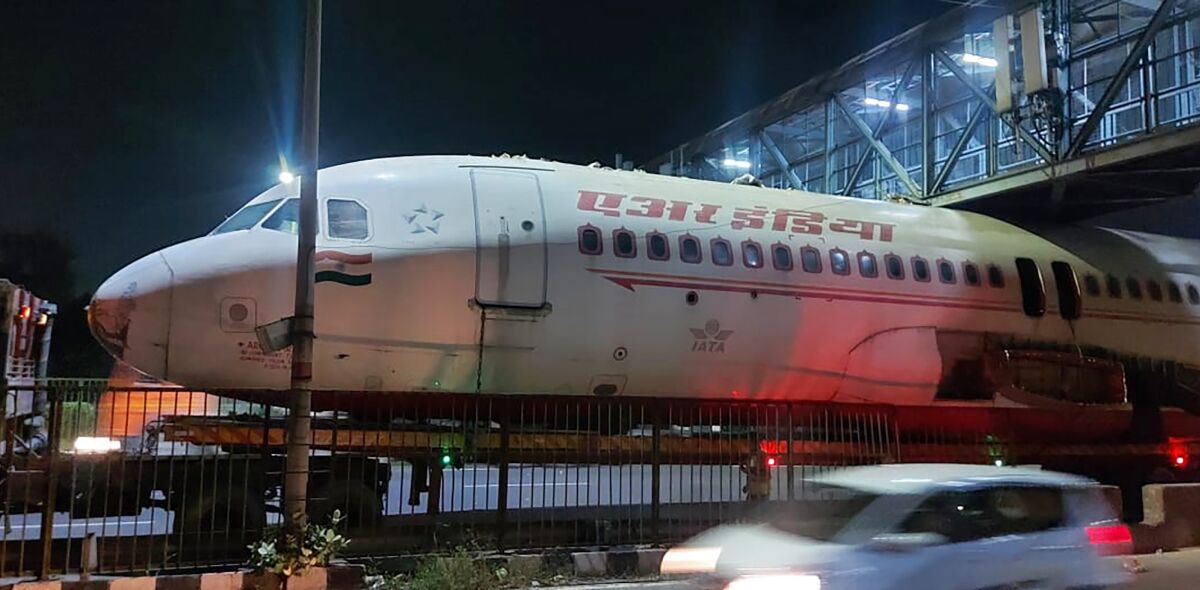 A scrapped Air India aircraft is seen stuck under a pedestrian overbridge in New Delhi, India, Sunday, Oct. 3, 2021. The plane was reportedly being transported by its new owner who purchased it from the airline. (Kshitiz Kakkar via AP)