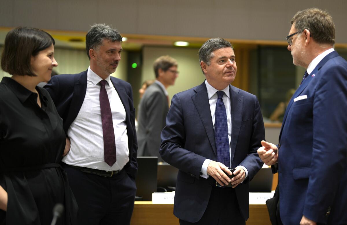 Czech Republic's Finance Minister Zybnek Stanjura, right, speaks with Ireland's Finance Minister Paschal Donohoe, second right, during a meeting of EU finance ministers in Brussels, Tuesday, July 12, 2022. The European Union is set on Tuesday to remove the final obstacles for Croatia to adopt the euro, ensuring the first expansion of the currency bloc in almost a decade. (AP Photo/Virginia Mayo)