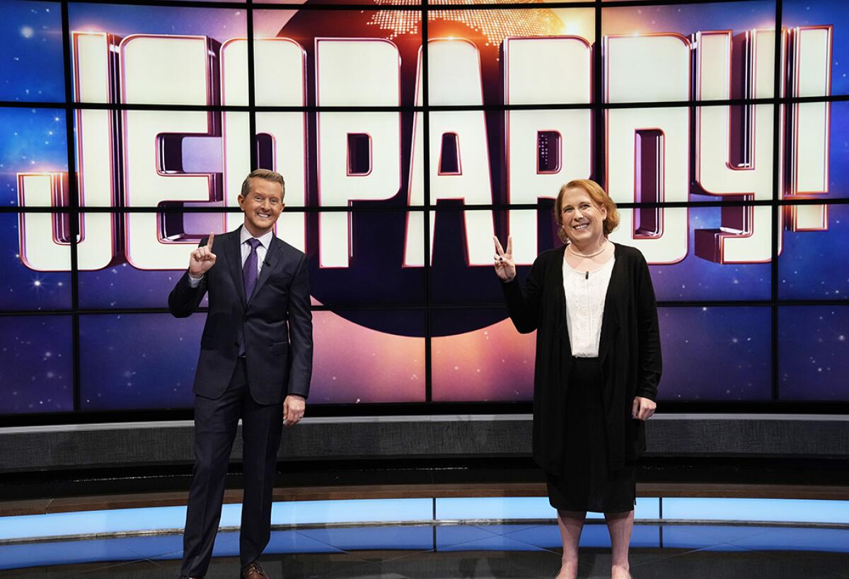Ken Jennings, left, holding up one finger and Amy Schneider holding up two fingers on the set of 'Jeopardy!'
