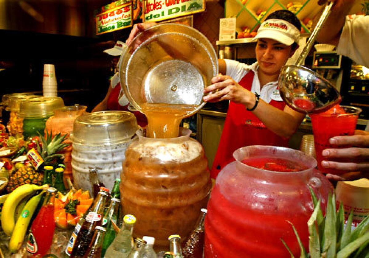 A server at the Vallarta Supermarket in Burbank fills a jug with tamarind juice. Aguas frescas are traditional Mexican fruit juices served fresh and cold.