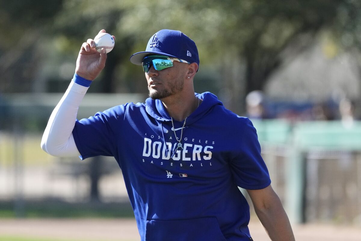 The Dodgers' Miguel Rojas holds a ball up.