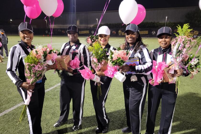 Football officials Kim Bly, LaQuica Hawkins, Crystal Nichols, Zina Jones and Connie Wells pose for a photo Friday night.