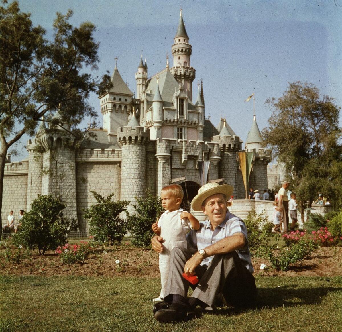 Walt Disney and his grandson Christopher Disney Miller relax near Sleeping Beauty Castle in the 1950s.