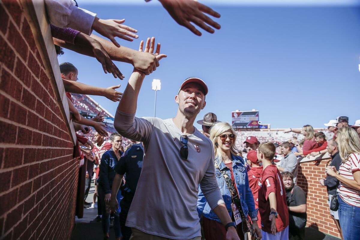 Oklahoma coach Lincoln Riley high-fives fans following a 2019 win over West Virginia