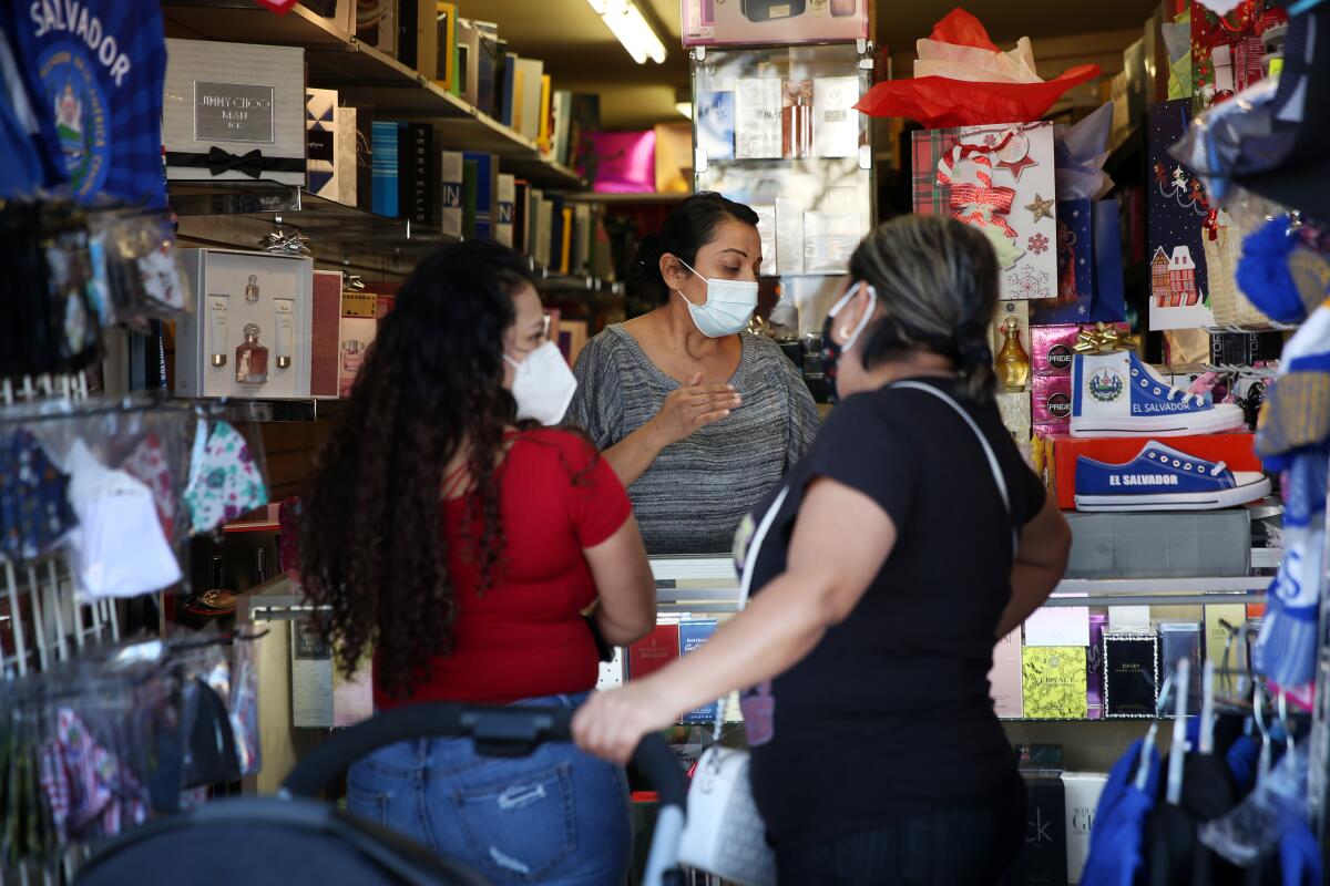 Silvia Orellana assists customers at the counter of her shop Orellana's Perfumes in Huntington Park.
