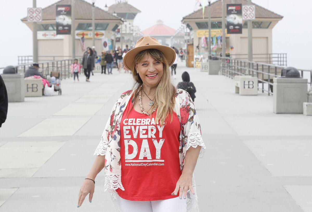 Cindy Lee, shown walking at the pier in Huntington Beach on Monday, started her Bucket List Coach Brand in 2012.