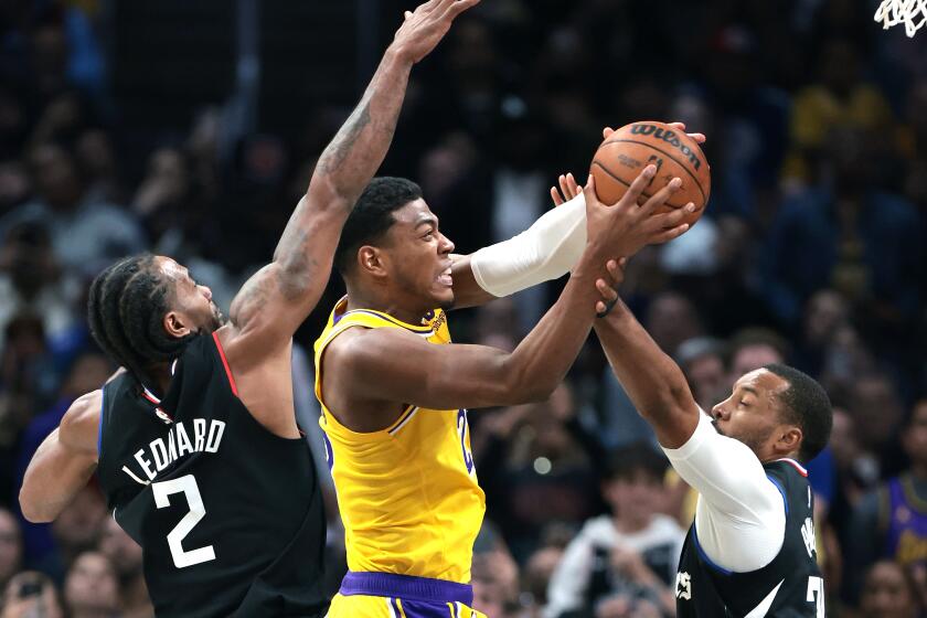 Los Angeles, California February 28, 2024-Lakers Rui Hachimura drives between Clippers Kawhi Leonard (2) and Norman Powell in the fourth quarter at Crypto.com Arena Wednesday. (Wally Skalij/Los Angeles Times)