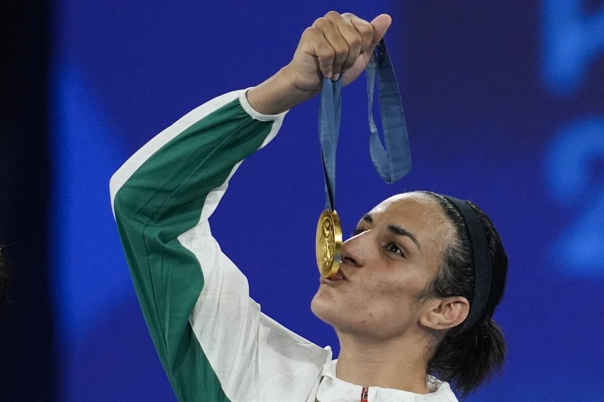 FILE - Gold medalist Algeria's Imane Khelif kisses her  