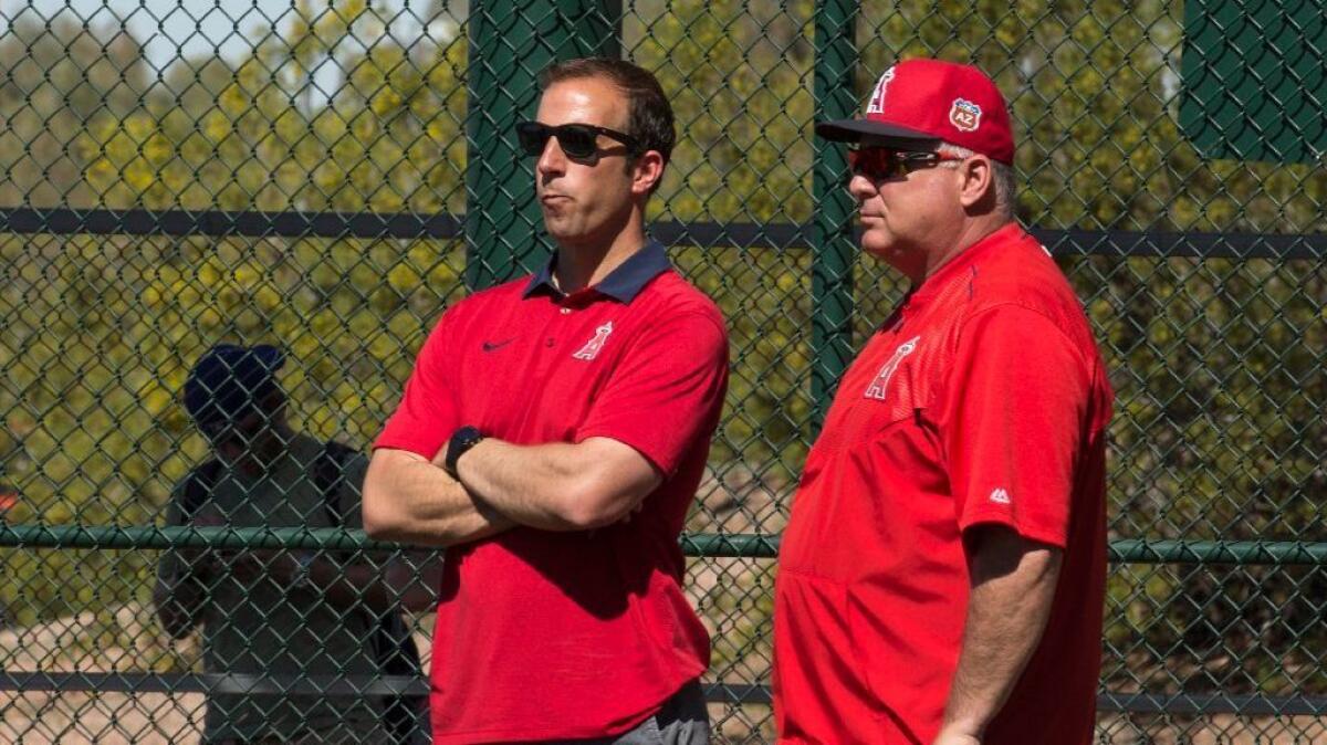 Angels General Manager Billy Eppler and Manager Mike Scioscia talk during batting practice at spring training on Feb. 26.