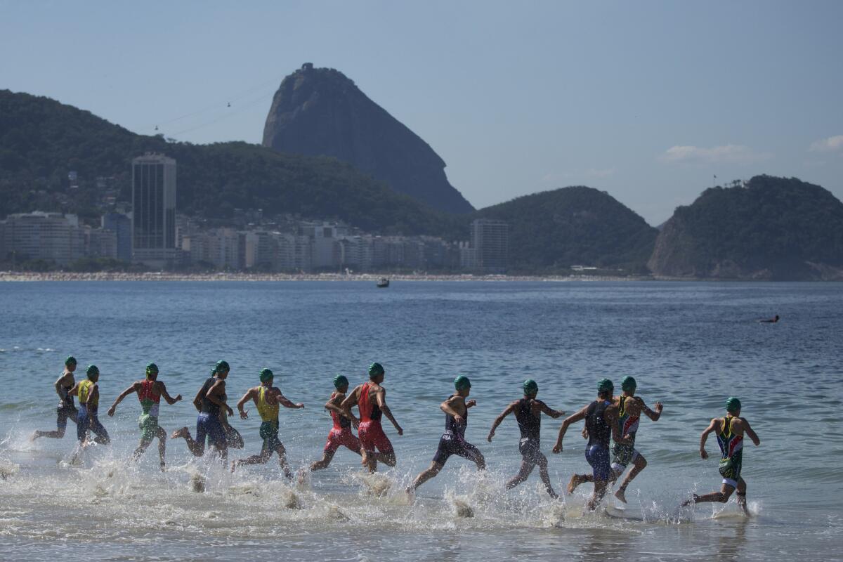 Triathletes enter the water at the start of the men's triathlon ITU World Olympic Qualification Event at Copacabana beach in Rio de Janeiro on Aug. 2.