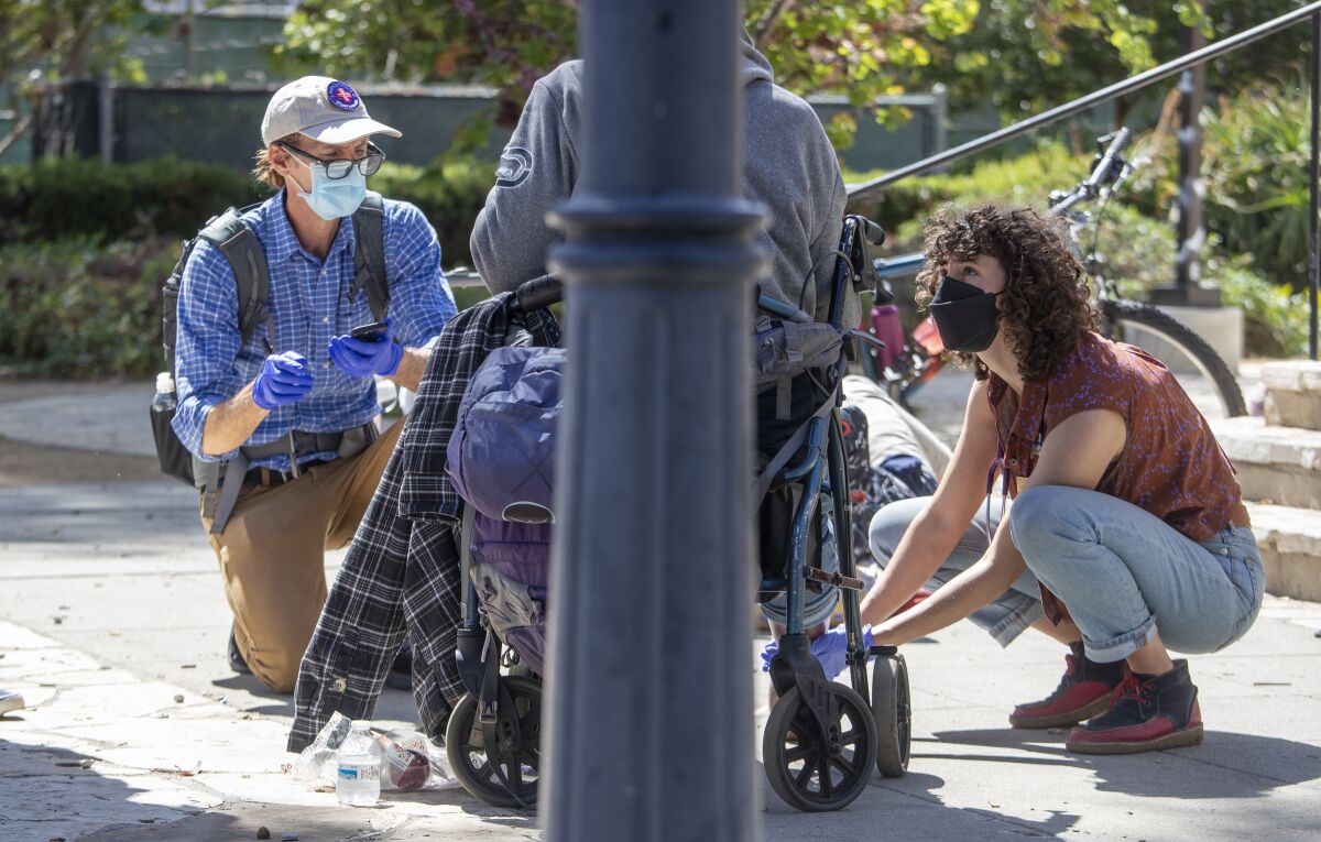 Dr. Coley King, left, and physician assistant student Francesca Reinisch talk with a homeless patient in Santa Monica.