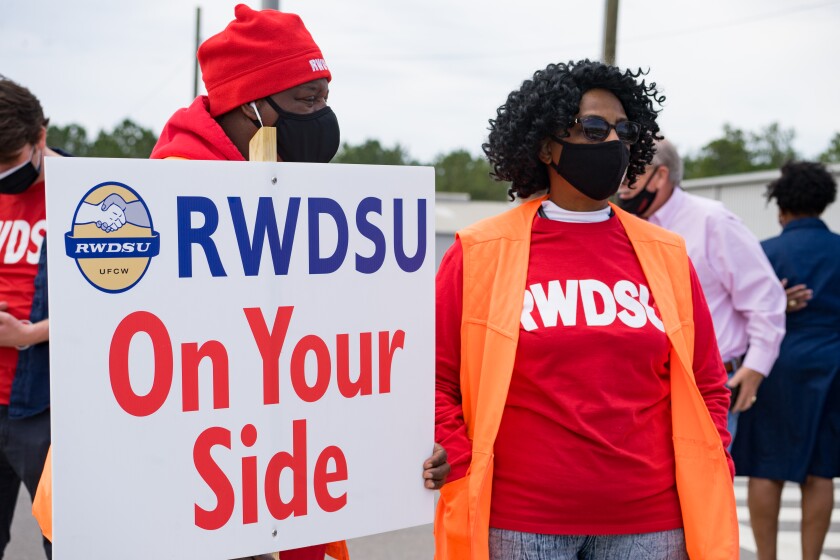 People wear shirts that say "RWDSU" and a sign that says "RWDSU: On your side."