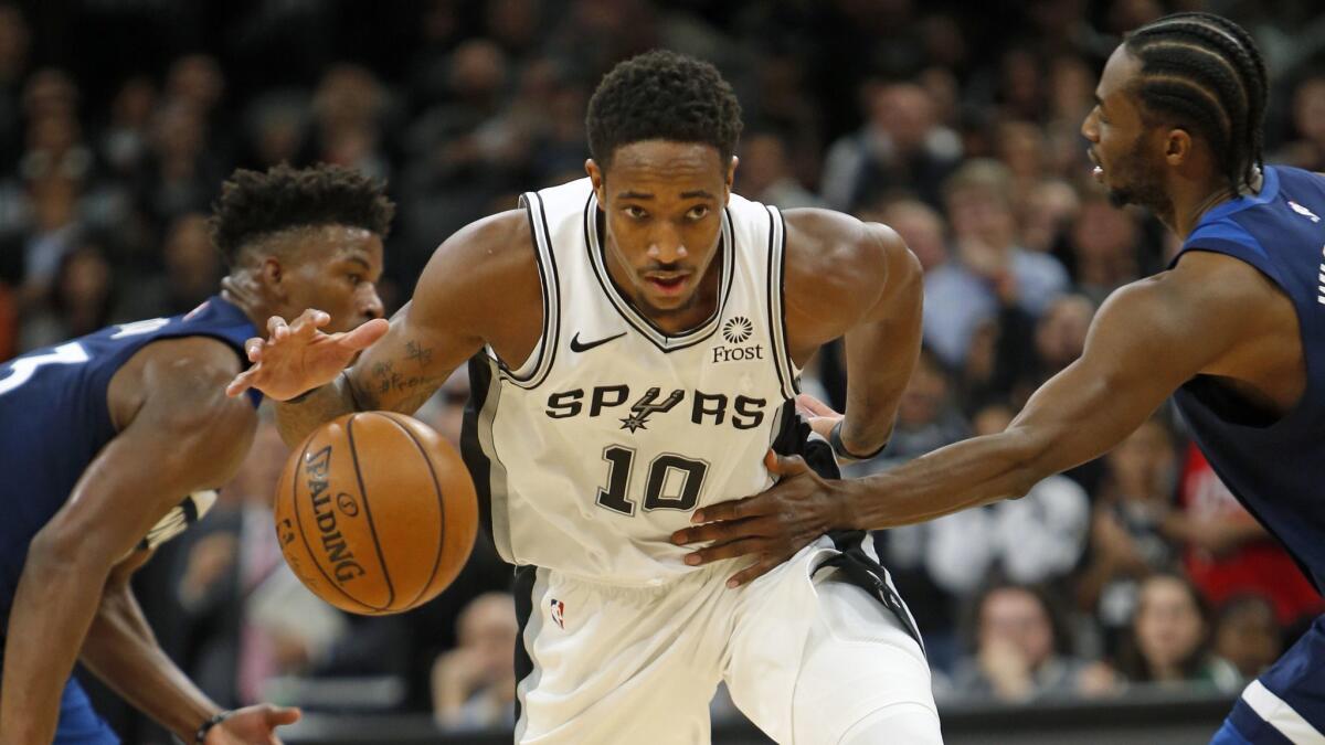 DeMar DeRozan of the San Antonio Spurs is fouled by Andrew Wiggins (right) of the Minnesota Timberwolve.