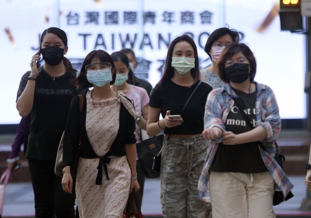 In this July 8, 2021, file photo, people wear face masks to protect against the spread of the coronavirus after the COVID-19 alert raise to level 3 in Taipei, Taiwan. Two Taiwanese high-tech companies announced a donation Monday of 10 million doses of the anti-coronavirus vaccine developed by Germany’s BioNTech to the island’s government. (AP Photo/Chiang Ying-ying, File)