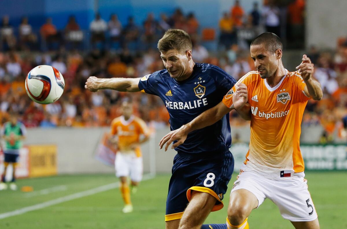 Steven Gerrard, left, battles for the ball with the Dynamo's Raul Rodriguez during the Galaxy's 3-0 loss on Saturday night in Houston.