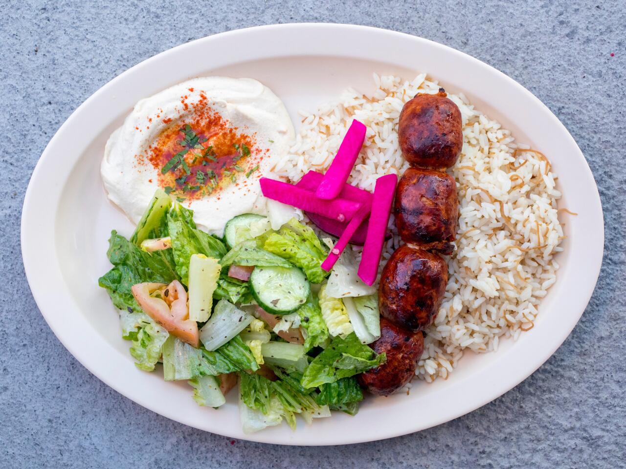 Chorizo kebab served with rice, Lebanese salad and hummus at X'tiosu Kitchen in Boyle Heights.