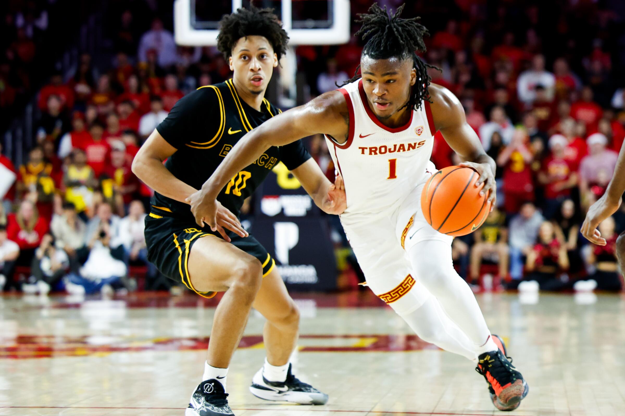 USC guard Isaiah Collier drives to the basket in front of Long Beach State guard AJ George.