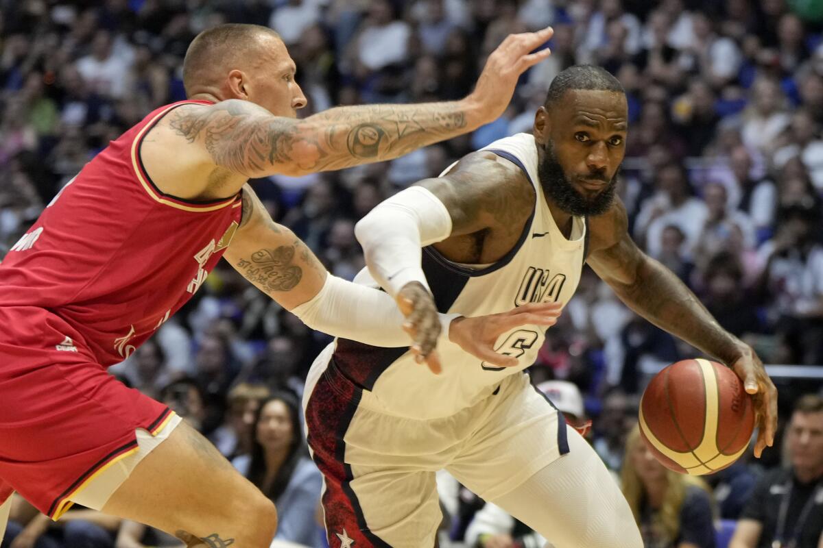 Germany's forward Daniel Theis, left, tries to block United States forward LeBron James from driving to the basket.