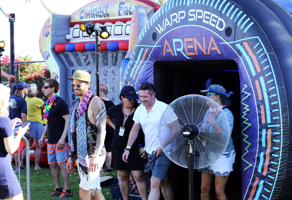 Guests are all smiles after playing "Connect Four" and walking into "Warp Speed Arena" at the Laguna Beach Pride Festival.
