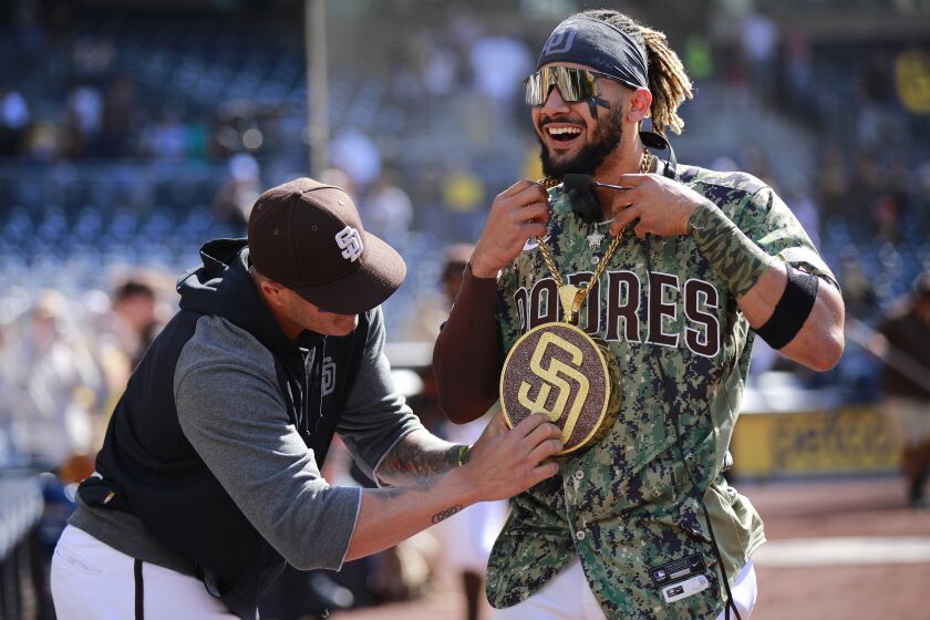 Manny Machado puts the Padres' new 'Swagg Chain' on Fernando Tatis Jr. 