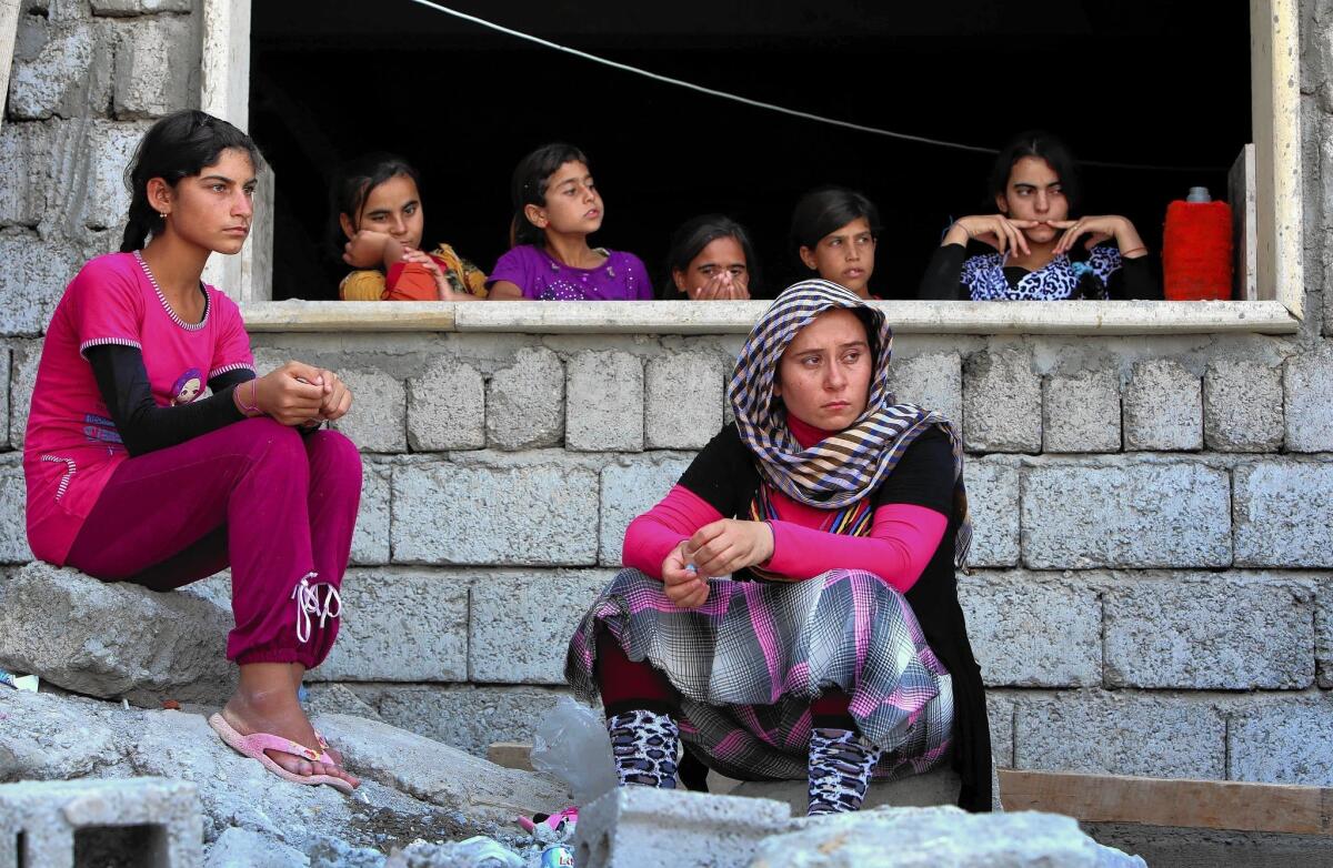 Iraqis who fled the violence in the town of Sinjar sit at a school in Dohuk where they found shelter. About 40,000 people remain trapped on Mt. Sinjar.
