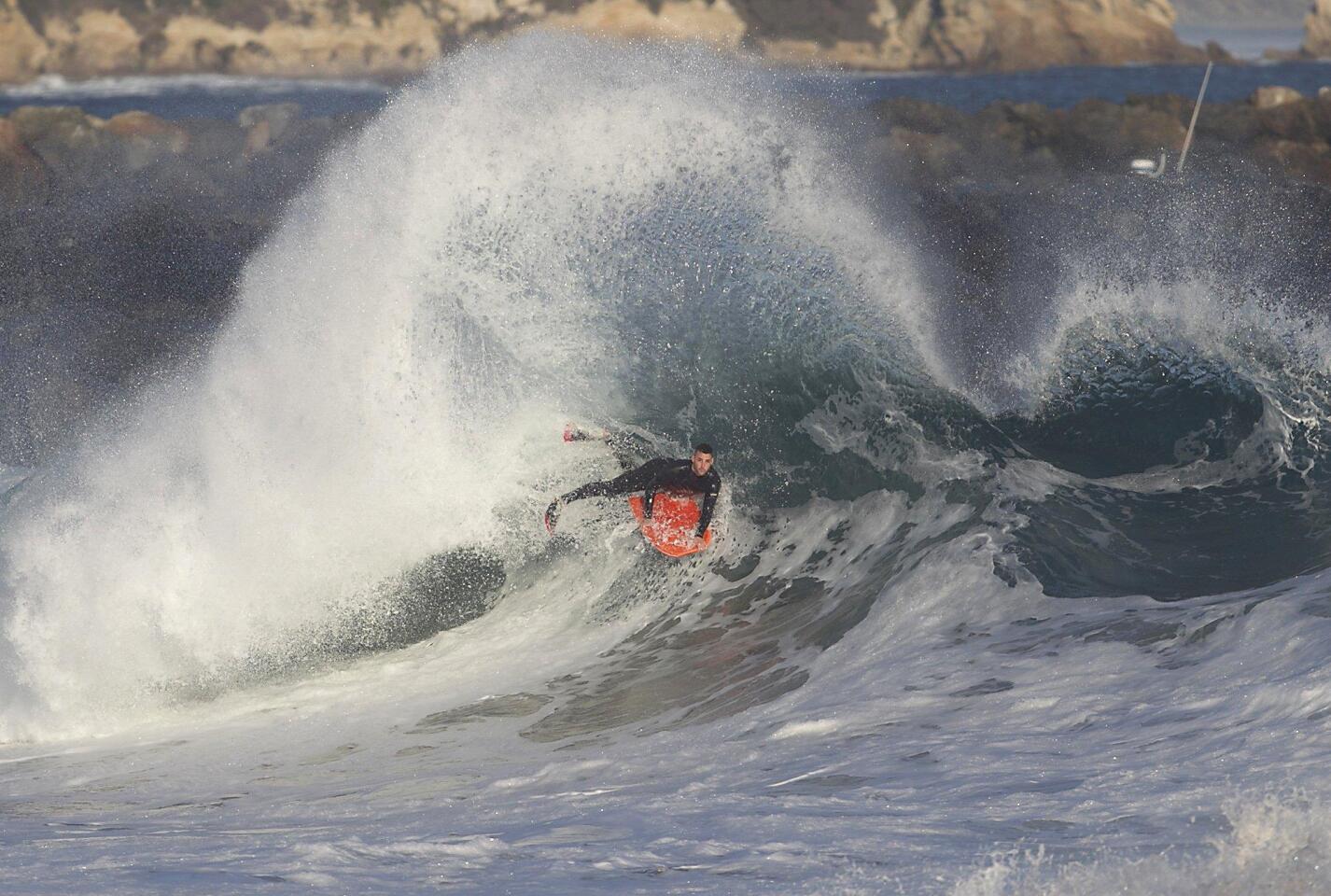 A bodyboarder hangs on tight as backwash hits an oncoming wave at the Wedge Friday.