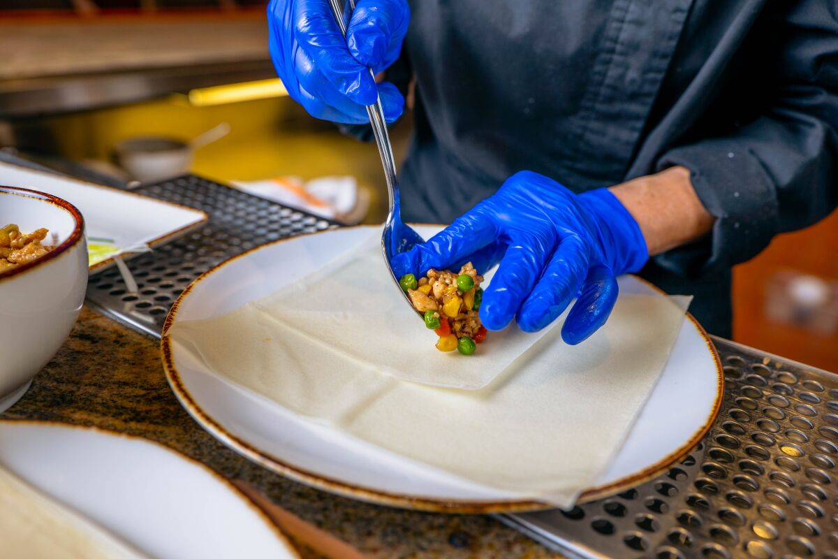 The cooled chicken mixture is set on a layered spring roll wrapper.