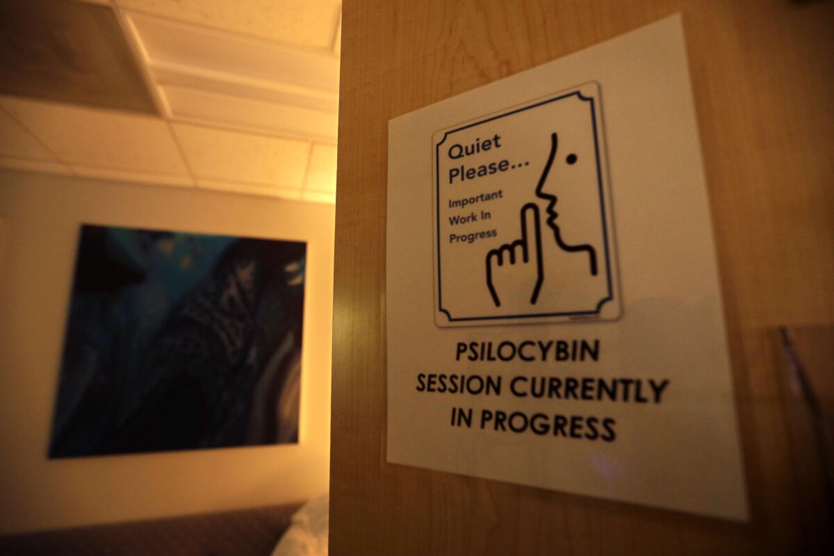 A sign on a door tells people to be quiet while a psilocybin session is in progress