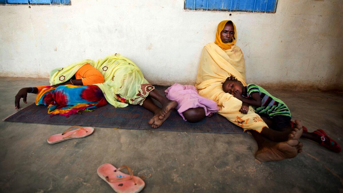 In this May 2013 file photo, sick women and children wait to be treated for suspected malaria at a hospital in North Darfur, Sudan.