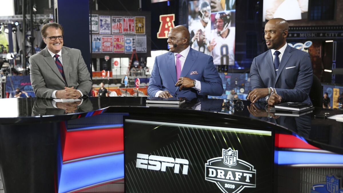 Mel Kiper Jr., left, Booger McFarland and Louis Riddick on the set of ESPN's 2019 NFL Draft coverage