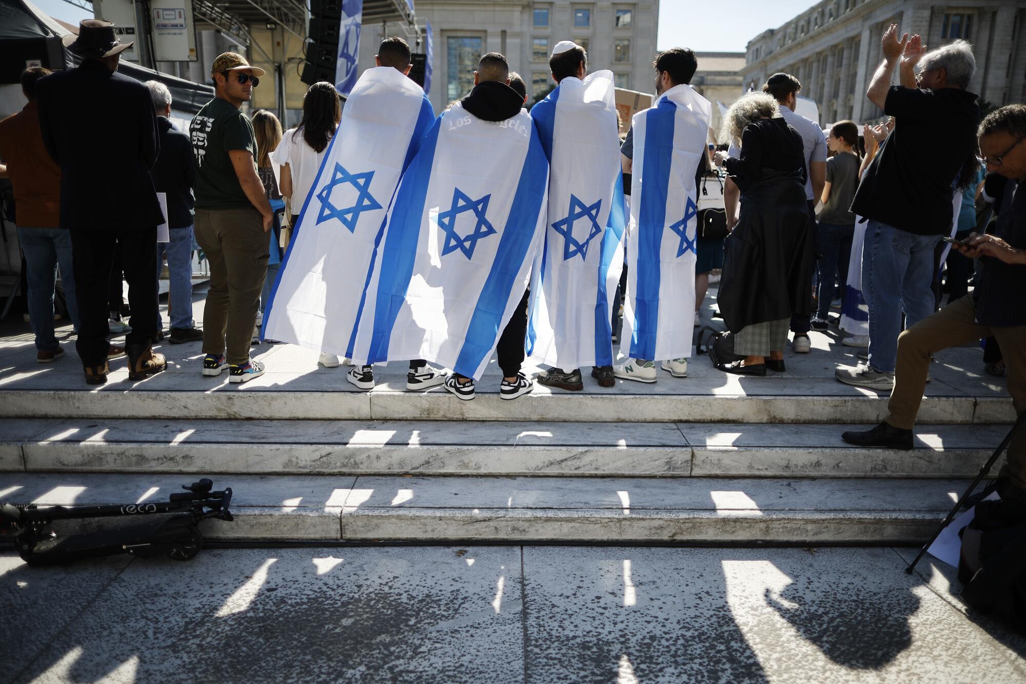  People draped with Israeli flags join a demonstration.