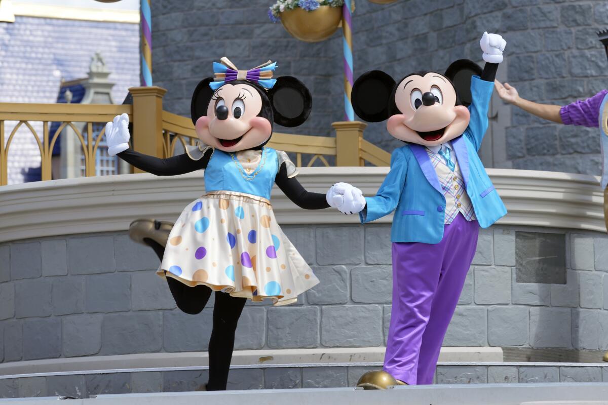 Minnie and Mickey Mouse perform for guests during a musical show in the Magic Kingdom