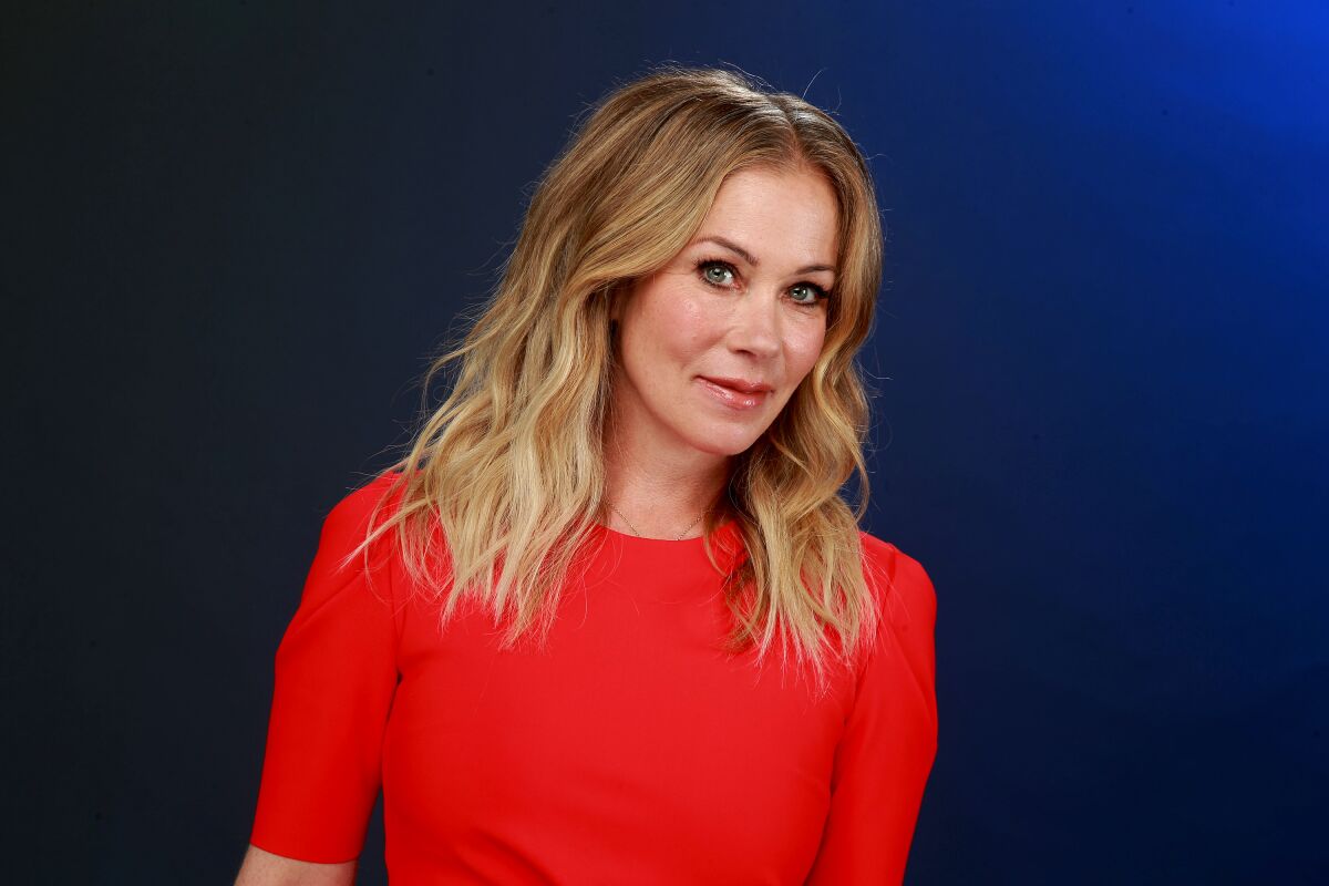 Christina Applegate wears a vibrant red dress for a portrait.