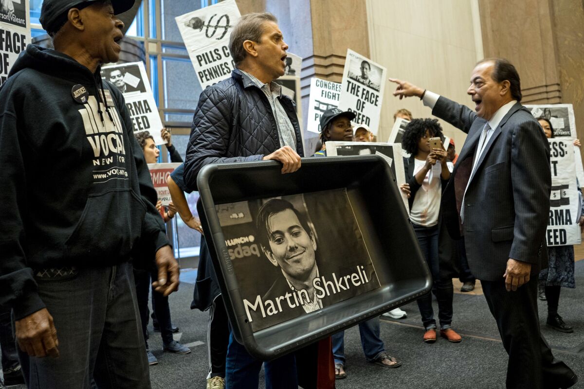 Protesting high drug prices, AIDS activists and other demonstrators carry images of Turing Pharmaceuticals then-CEO Martin Shkreli in October 2015. Shkreli drew attention for a 5,000% price increase on a life-saving drug.