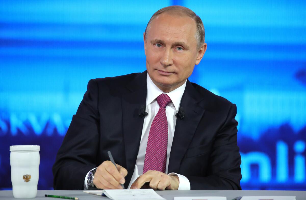 Russian President Vladimir Putin makes notes as he listens to a question during his annual televised call-in show in Moscow on June 15.