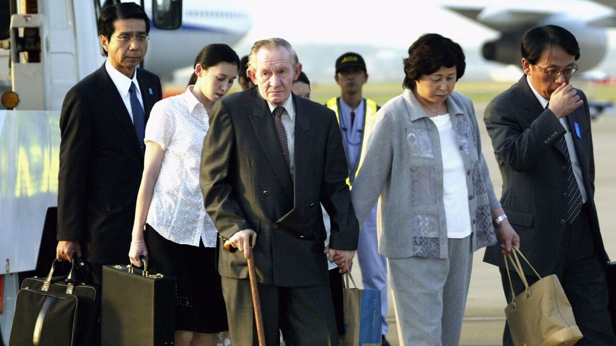 Charles Robert Jenkins and his wife, Hitomi Soga, arrive in Tokyo on July 18, 2004. They were forced together in North Korea, but bonded over their hatred of the regime and fell in love.