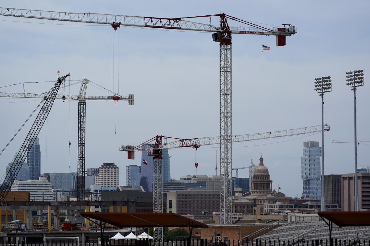 Construction cranes hover over downtown and near Austin, Texas. 