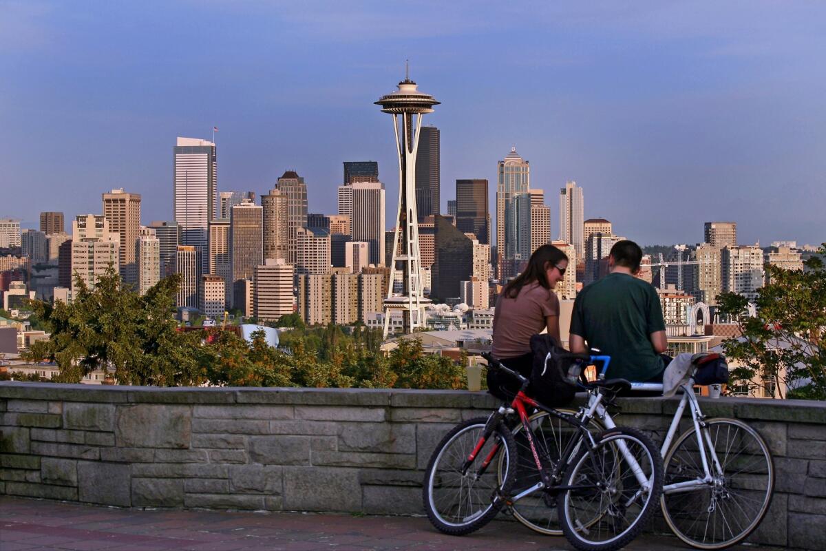 A bike break with a view of the Seattle cityscape. The city is making some neighborhoods friendlier for walkers and bikers.