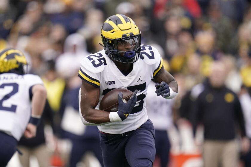 Michigan running back Hassan Haskins runs with the ball against Maryland during the first half of an NCAA college football game between Maryland and Michigan, Saturday, Nov. 20, 2021, in College Park, Md. Michigan won 59-18. (AP Photo/Julio Cortez)