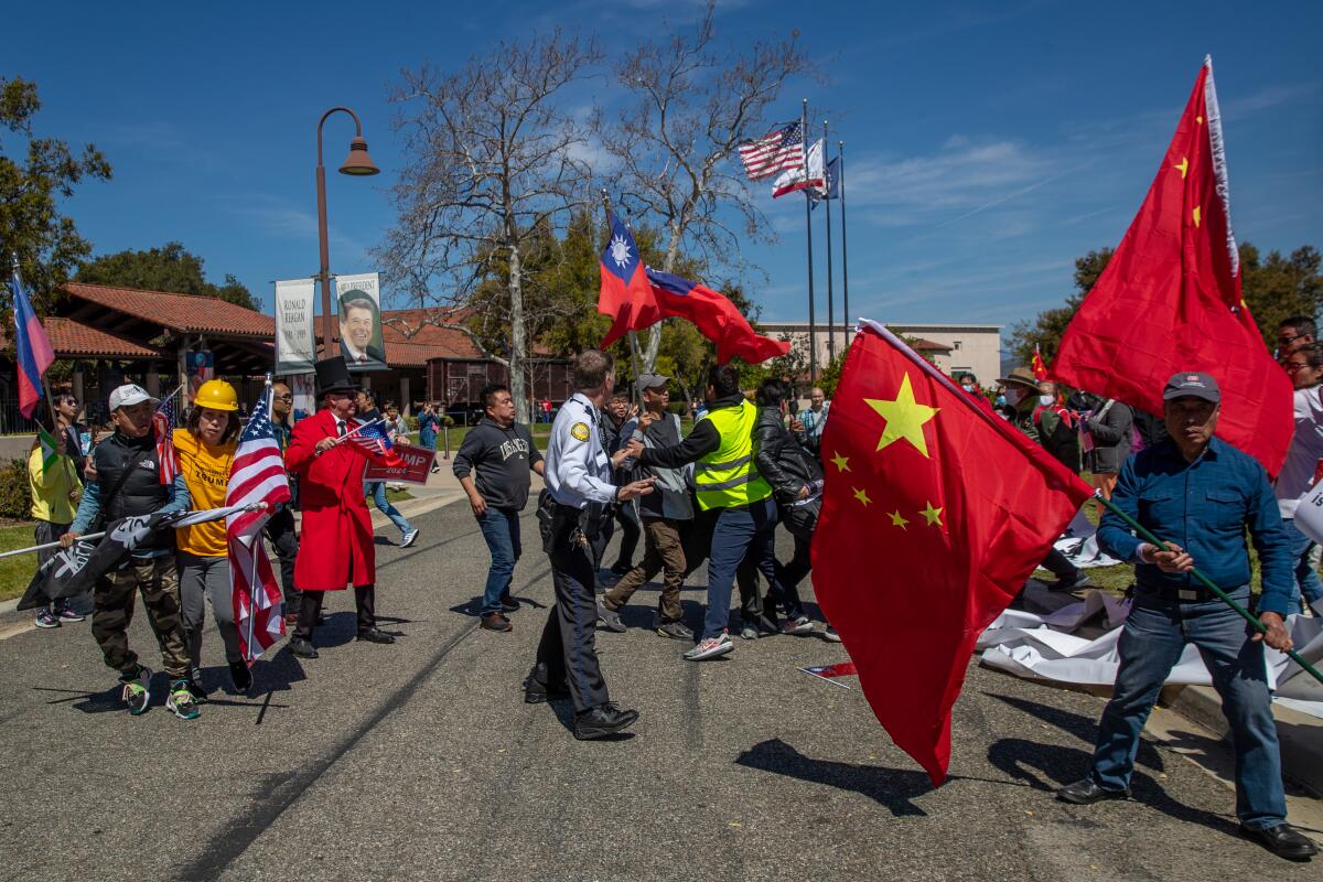 Protesters with Chinese and American flags near Ronald Reagan Presidential Library