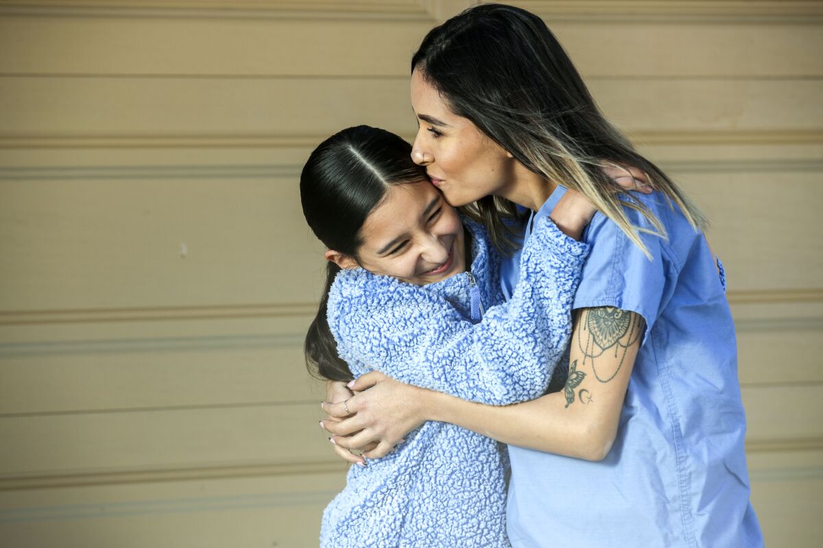Annel Meza hugs her 11-year-old daughter Naima Villa.